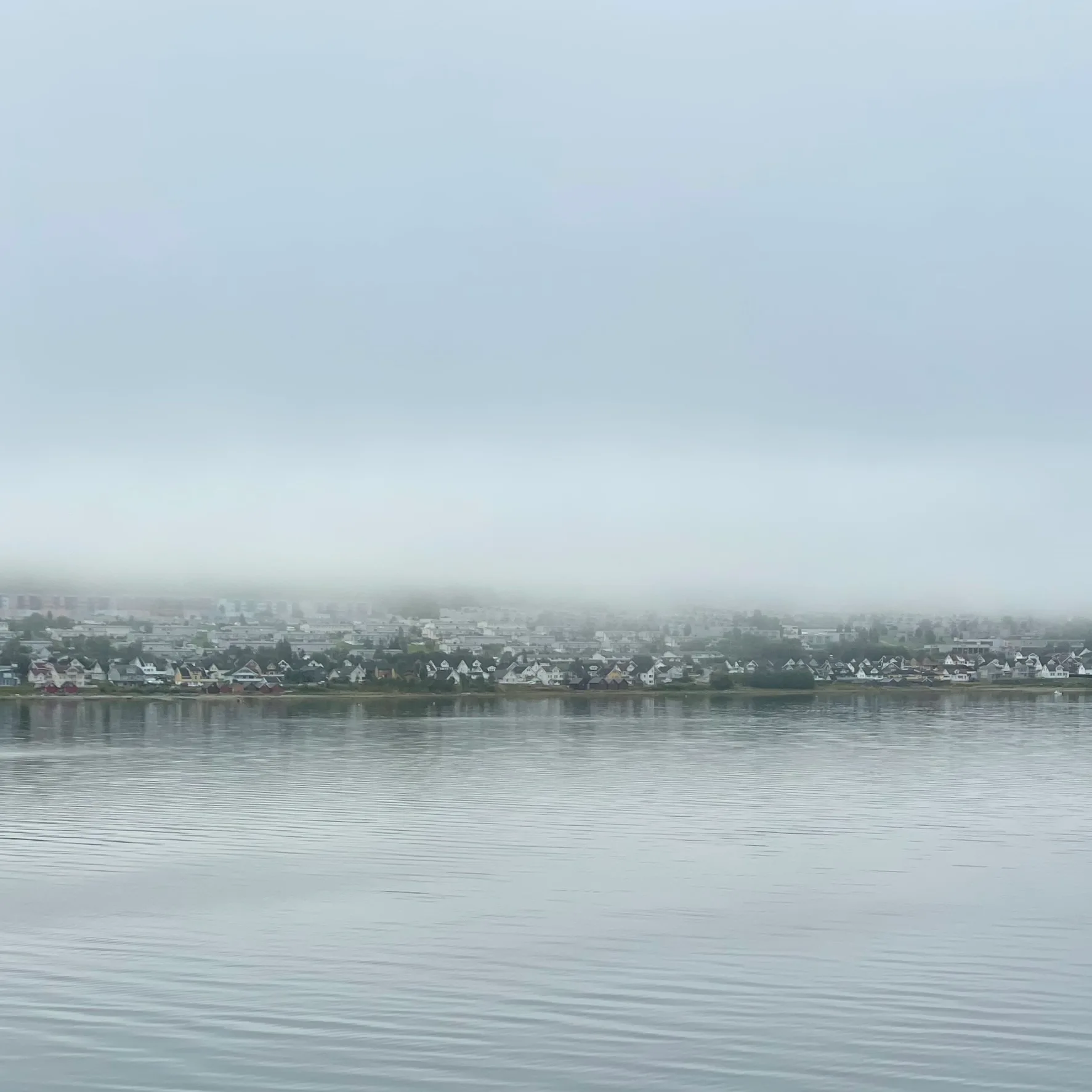 Ethereal misty coastal scene with calm waters reflecting heaven's fog, capturing the liminal threshold between visible and invisible worlds